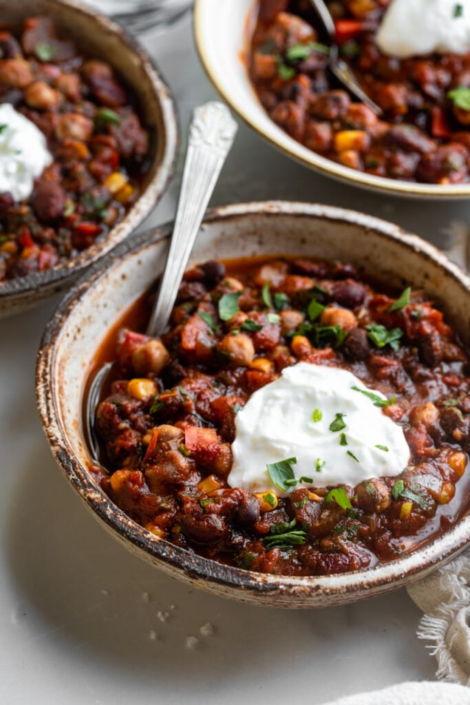 several bowls of Crockpot Vegetarian Chili with spoons